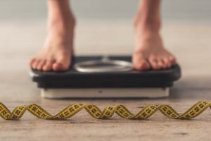 person being weighed for their life insurance exam for overweight