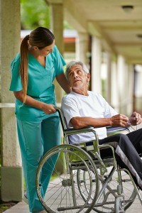 lady pushing older man in a wheelchair