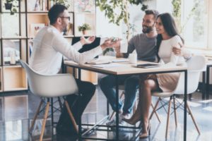 young unmarried couple discussing life insurance with an agent