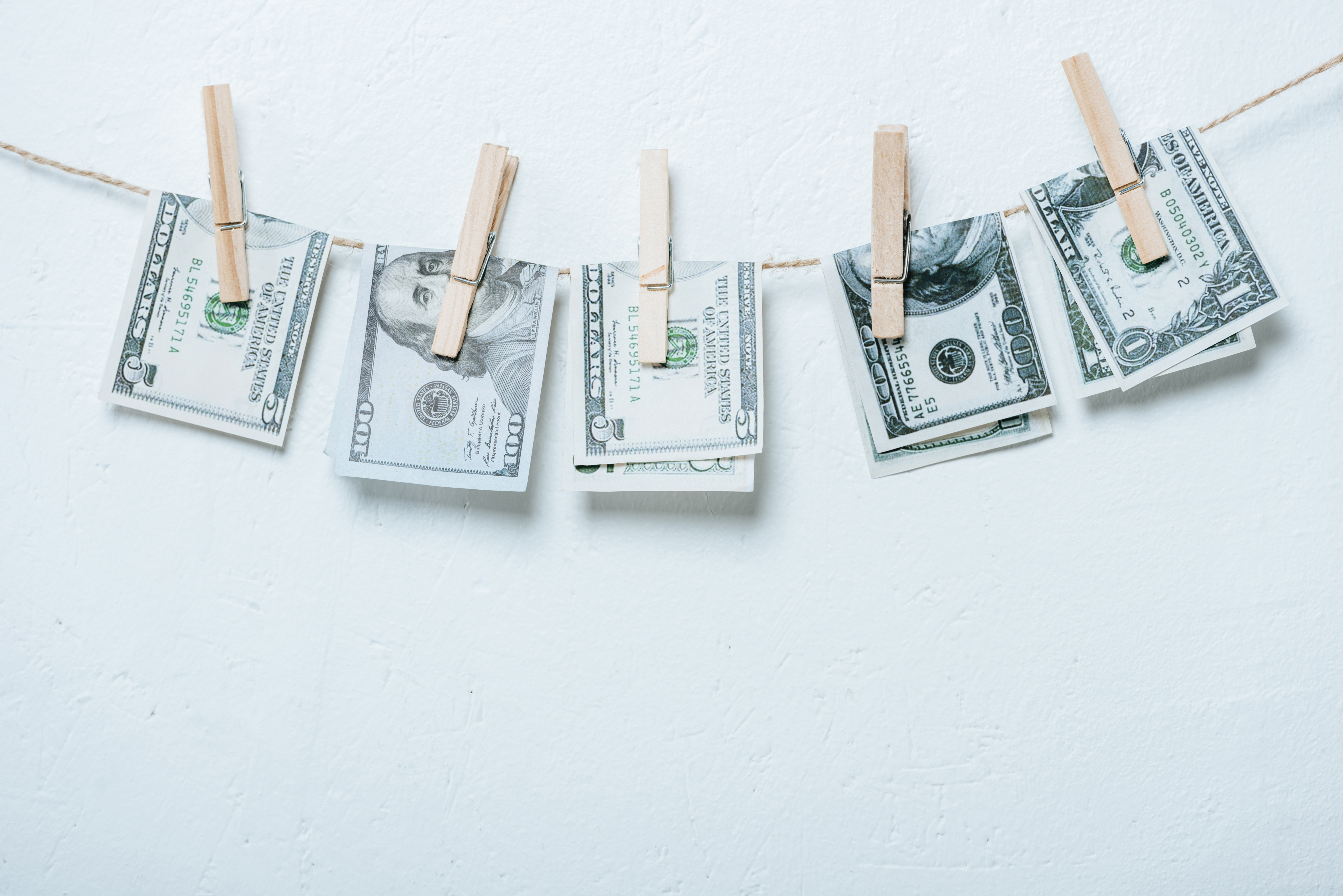 several ads of cash hanging from a clothes line with clothes pins