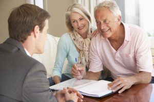 happy older couple sitting and planning estate with young lawyer man 