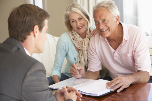 happy older couple sitting and planning estate with young lawyer man